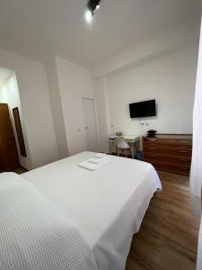 1 dormitorio con 1 cama blanca y TV de pantalla plana en 2 Passi Da, en Roma