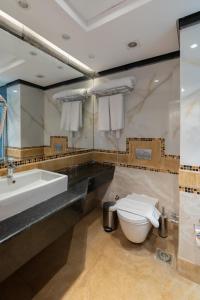 Safir Marsa Matrouh Resort في مرسى مطروح: حمام مع حوض أبيض ومرحاض