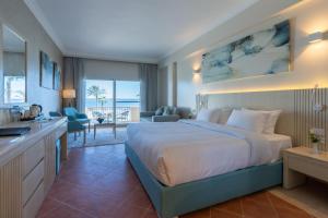 a hotel room with a large bed and a kitchen at Safir Marsa Matrouh Resort in Marsa Matruh