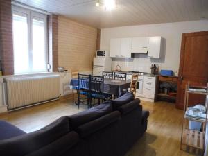 Una sala de estar con un sofá y una mesa y una cocina. en Appartement spacieux dans rue calme, en Wimereux