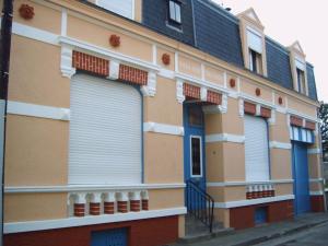 un edificio con puertas y ventanas azules en una calle en Appartement spacieux dans rue calme, en Wimereux
