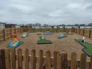 a playground with colorful play equipment in a fence at 17 Breakaway Chalet in Great Yarmouth