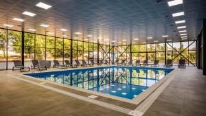 una piscina en un edificio con un gran grupo de ventanas en Akhaltsikhe Inn en Akhaltsikhe