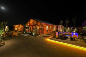 a house with a patio at night with lights at منتجع المروج in Khalij Salman