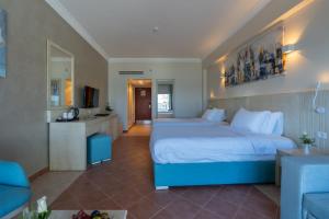 Safir Marsa Matrouh Resort في مرسى مطروح: غرفة فندقية بسرير كبير ومطبخ