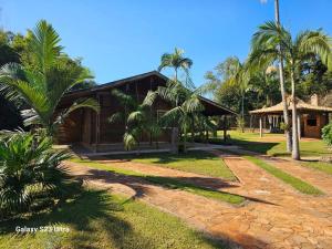 una casa con palmeras delante en Chácara Belvedere.Espaço rural, descanso e lazer en Londrina