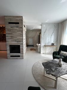 ein Wohnzimmer mit einem Kamin und einem Tisch in der Unterkunft Secret Place apartments, luxury and spa 