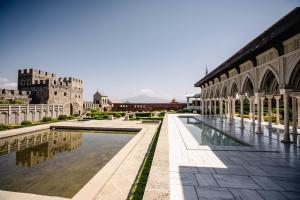 a view of a building with a pool and a castle at Akhaltsikhe Inn in Akhaltsikhe
