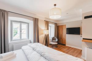 a hotel room with a bed and a tv at Penzion KOVÁRNA in Český Krumlov