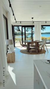 una sala de estar blanca con mesa y sillas en Beautiful Villa by the sea en Porvoo
