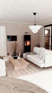 a living room with a white couch and a chandelier at Beautiful Villa by the sea in Porvoo