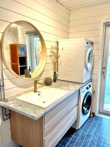 a bathroom with a sink and a washing machine at Beautiful Villa by the sea in Porvoo
