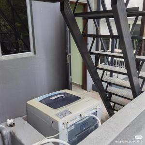 un ordinateur posé sur le sol à côté d'un escalier dans l'établissement 2号房有厕所厨房冰箱洗衣机, à Kuala Lumpur