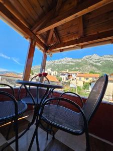 a table and chairs on a balcony with a view at Castle - inside,Voga Guesthause in Krujë