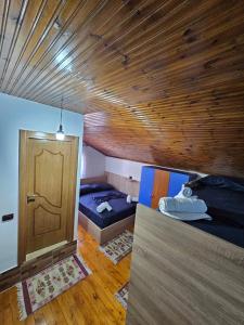 Habitación con 2 camas y puerta de madera en Voga Guesthouse en Krujë