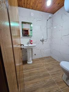 a bathroom with a sink and a toilet and a mirror at Castle - inside,Voga Guesthause in Krujë +33 photos
