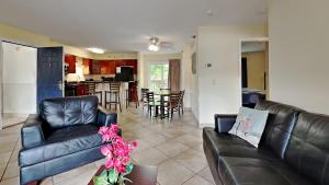 uma sala de estar com mobiliário de couro preto e uma cozinha em Put-in-Bay Poolview Condo #7 em Put-in-Bay