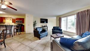 ein Wohnzimmer mit blauen Sofas und eine Küche in der Unterkunft Put-in-Bay Poolview Condo #4 in Put-in-Bay
