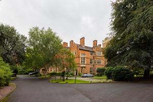 a large brick building with cars parked in front of it at The Woking Wonder - Captivating 3BDR Flat with Parking in Woking