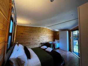 a bedroom with two beds in a room with wooden walls at 9 Serendipity Stay in George