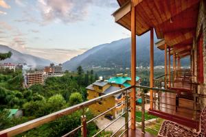 a view from the balcony of a house with mountains in the background at Snow City's Montana Blues Resort Manali - Heated & Air-Cooled Stay in Manāli