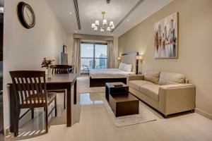 een woonkamer met een bank, een tafel en een bed bij Fantastic Spacious Apartment with Panoramic Views in Dubai
