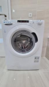a white washing machine sitting in a bathroom at Finnem Rentals Varnsdorfská in Prague