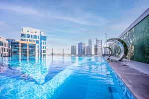 a swimming pool on top of a building with a city at Fantastic Spacious Apartment with Panoramic Views in Dubai