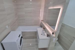 a bathroom with a sink and a washing machine at Finnem Rentals Varnsdorfská in Prague +10 photos