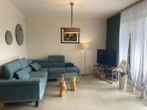 un soggiorno con divano blu e TV di Apartament Zen a Sobieszewo