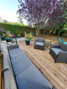 a wooden deck with two chairs and chairs on it at Chez T-E-O in Cognac