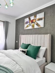 奈瓦沙的住宿－Naivasha Executive studio apartment，一间卧室配有带绿色和白色枕头的床