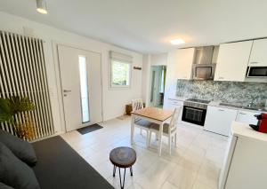 a living room with a table and a kitchen at Green Sun - a cozy apartment close to the airport in Opfikon