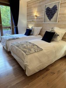 two beds sitting next to each other in a bedroom at Coté Forêt in Orbey