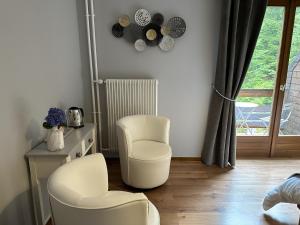 two white chairs in a room with a window at Coté Forêt in Orbey