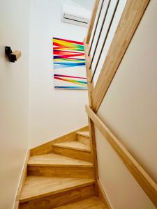 a staircase in a house with a painting on the wall at La Halte Occitane - Logement neuf 6 personnes 3 chambres tout confort in Montauban