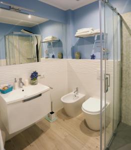 a bathroom with a toilet and a sink at Hotel Hiki 3 Superior in Bibione