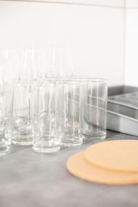 a group of glasses sitting on a counter with a plate at - Nice New York apartment in the heart of Duisburg - Betten & Sofa - 5 Mins Central Station Hbf - Big TV & WiFi - in Duisburg