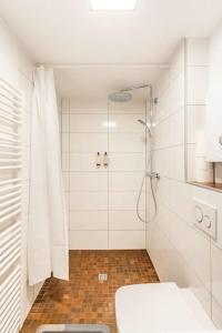 La salle de bains blanche est pourvue d'une douche et de toilettes. dans l'établissement - Nice New York apartment in the heart of Duisburg - Betten & Sofa - 5 Mins Central Station Hbf - Big TV & WiFi -, à Duisbourg