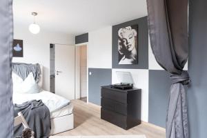 a bedroom with a bed and a desk with a laptop on it at - Nice New York apartment in the heart of Duisburg - Betten & Sofa - 5 Mins Central Station Hbf - Big TV & WiFi - in Duisburg