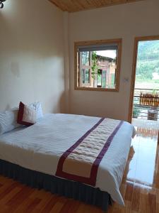 Schlafzimmer mit einem großen Bett und einem Fenster in der Unterkunft Moc's House in Bắc Hà