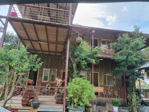 a house with a deck with trees in front of it at Moc's House in Bắc Hà