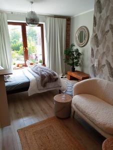 a bedroom with a bed and a chair and a window at Urocze Studio 7 z parkingiem in Katowice