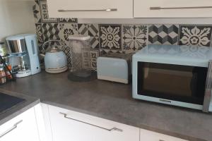 a kitchen counter with a microwave and other appliances at Appartement 80m2 6 couchages in Garidech