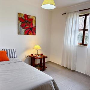 1 dormitorio con 1 cama y 1 mesa con lámpara en Casa Girasoles en Centenario