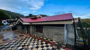 a house with a red roof and a staircase at Mountain View cottage in Ooty