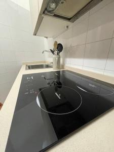 una cocina con encimera negra y fregadero en Casa vacanze Il Gianduiotto en Turín