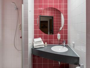 a bathroom with a sink and a mirror at B&B Hotel Hildesheim in Hildesheim