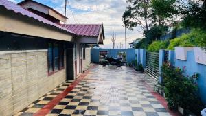 a motorcycle parked outside of a house with a fence at Mountain View cottage in Ooty