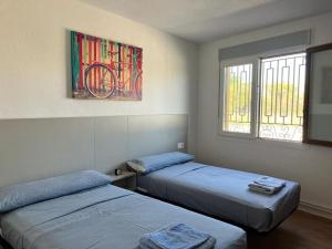 Habitación con 2 camas y una pintura en la pared. en Finca Viñas y Nogales, en Aranda de Duero